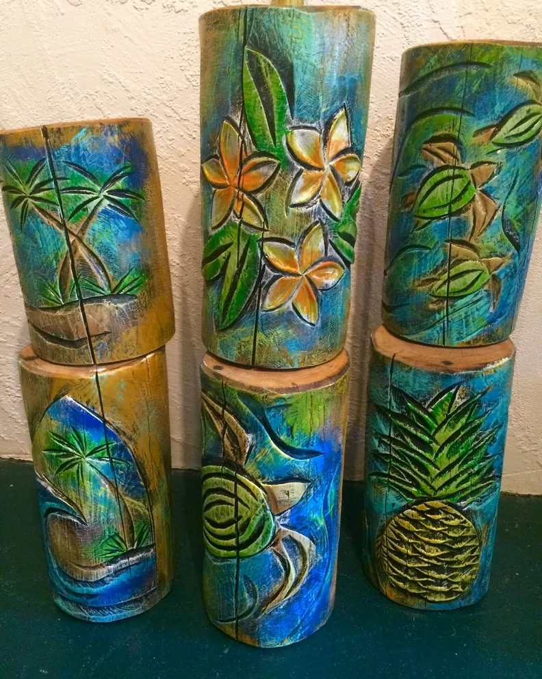 Painted wooden carvings with tropical flowers, palms, a turtle and pineapple