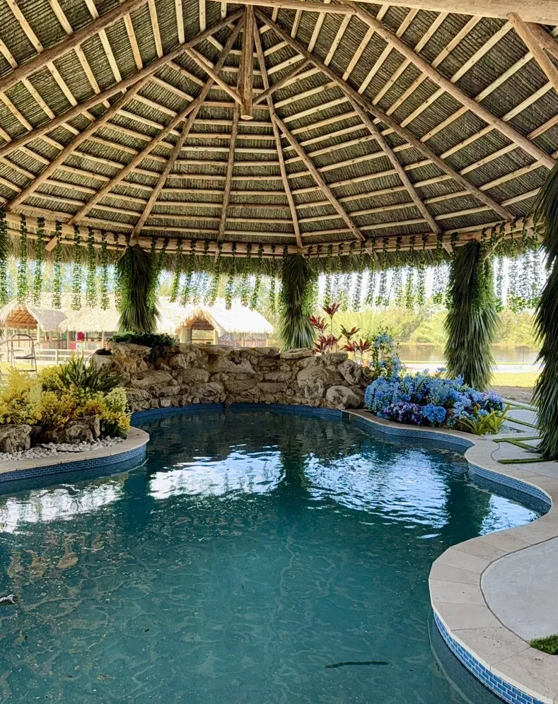 Palm-thatched roof and timber frame over a landscaped pool